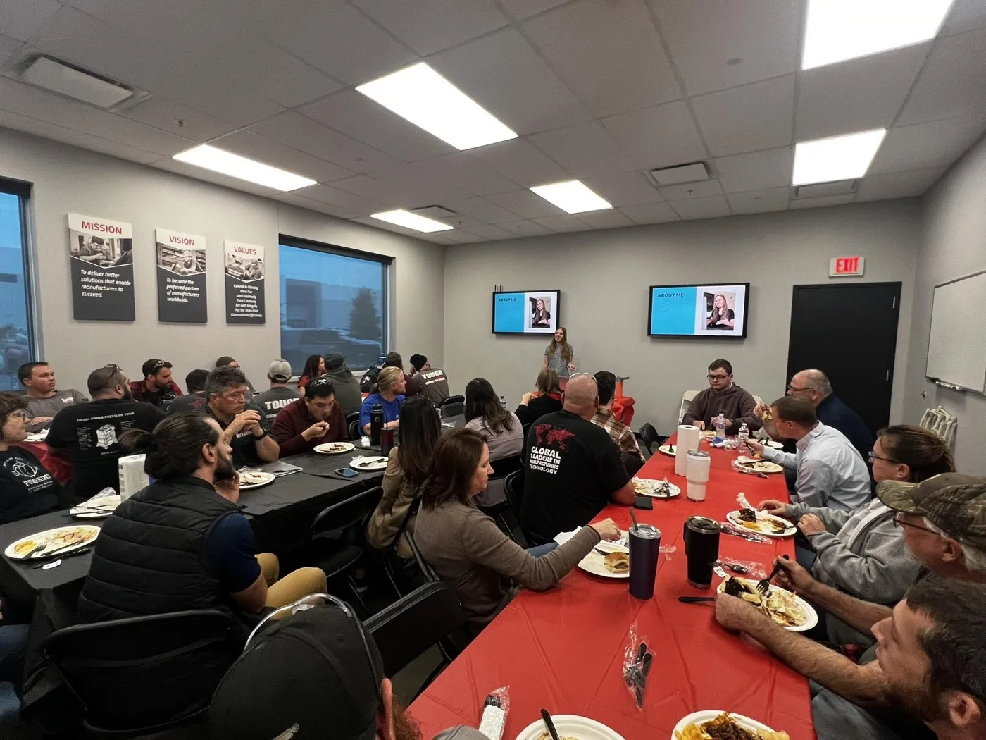 Abigail Parker leading a lunch and learn for a manufacturing team seated around tables in their conference room