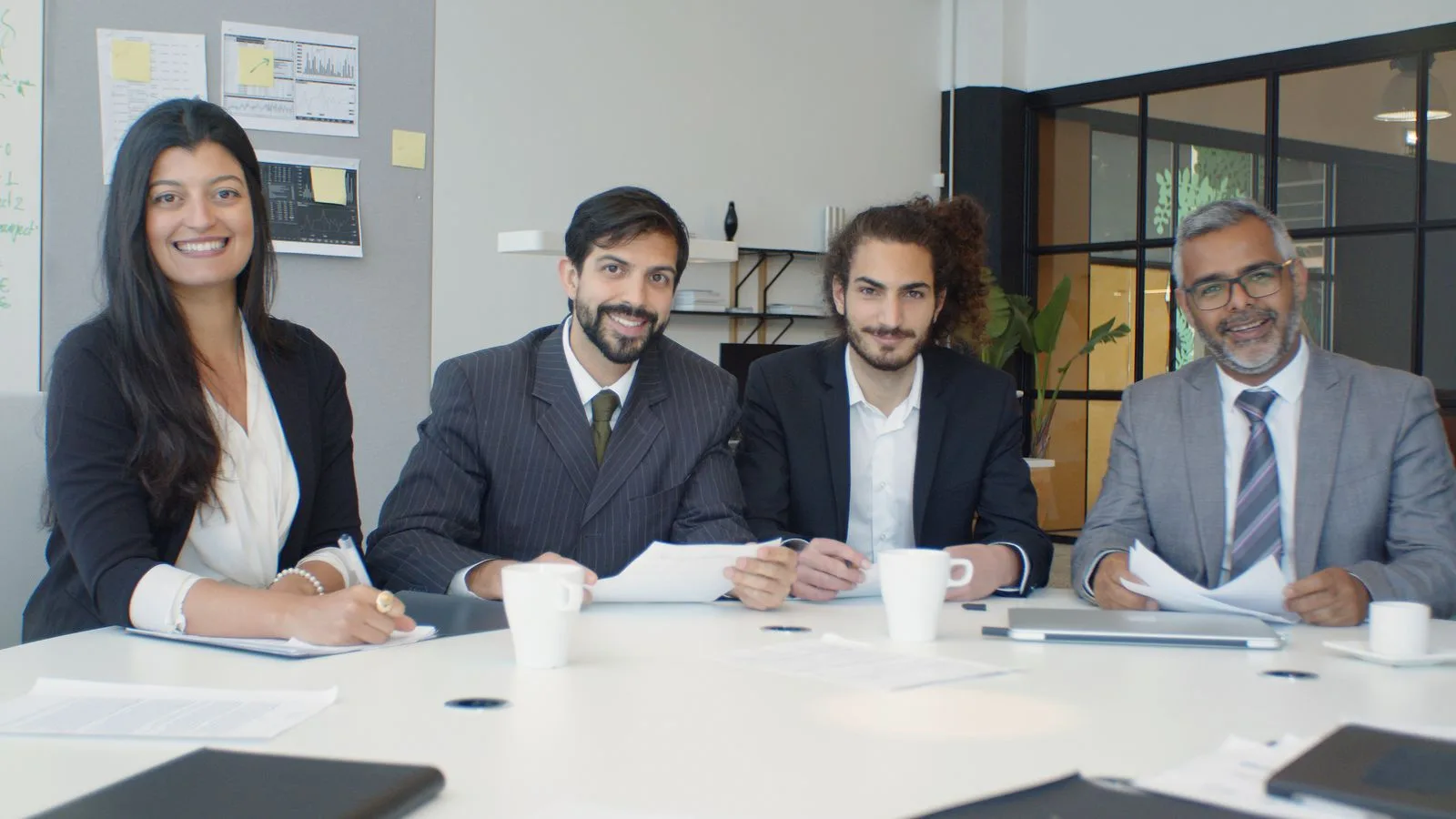 A confident corporate team gathered around a conference table, the kind of group that brings Abigail in